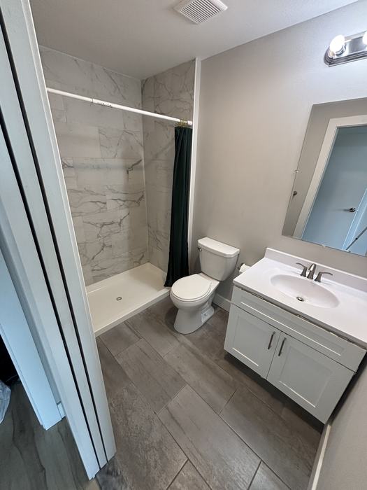 Clean bathroom with tiled shower and vanity