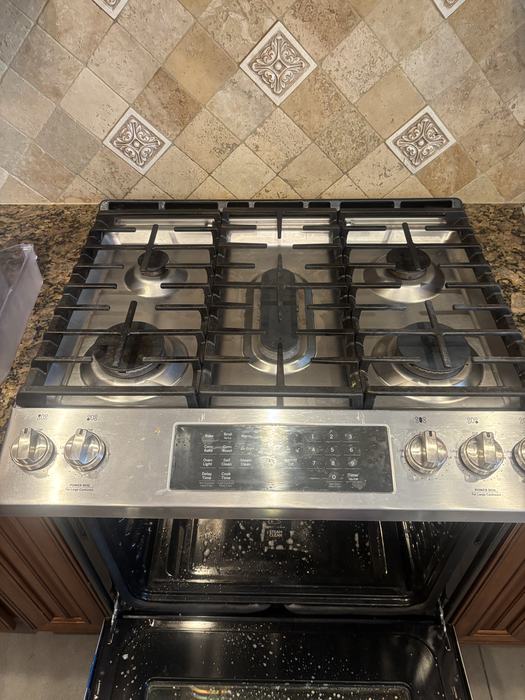 Gas range and oven being deep cleaned