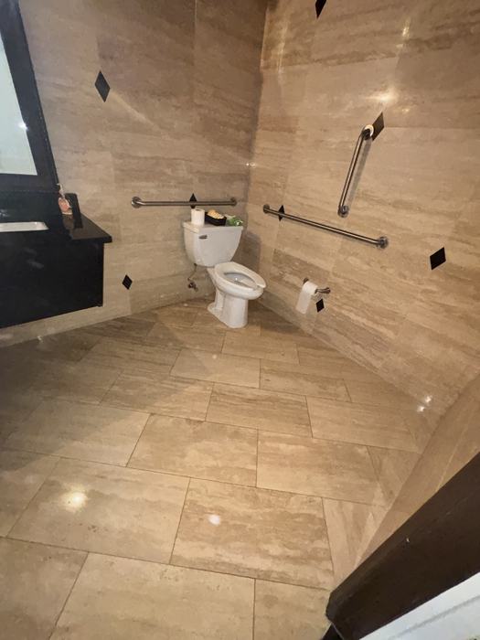 Commercial restroom with clean stone tile floor